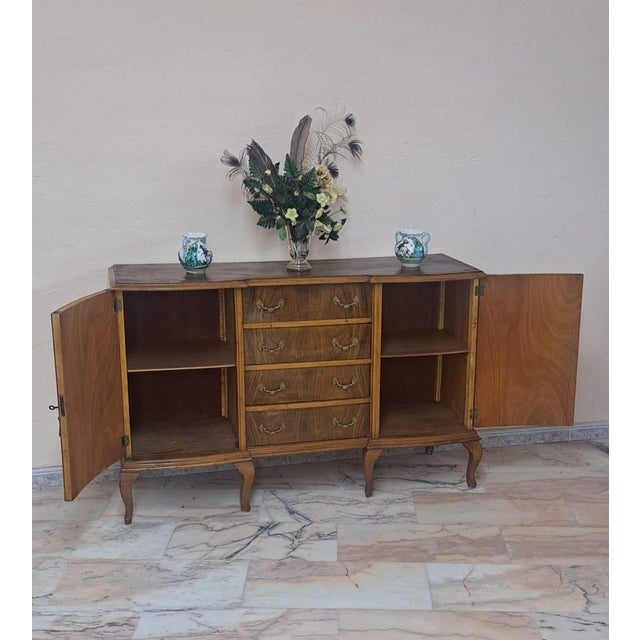 Classic 1950s style wooden sideboard. It features four central drawers with ornate bronze handles and two large side doors...