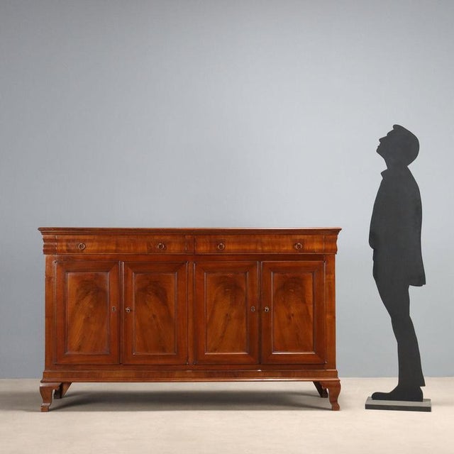 Walnut and crotchet sideboard. Pair of drawers in the molded band below the top, four paneled doors, and curved bracket...