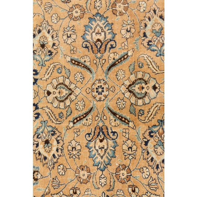An early 20th century Persian Mashad rug, the pale peach field with a delicate trellis design of palmettes, feathering...