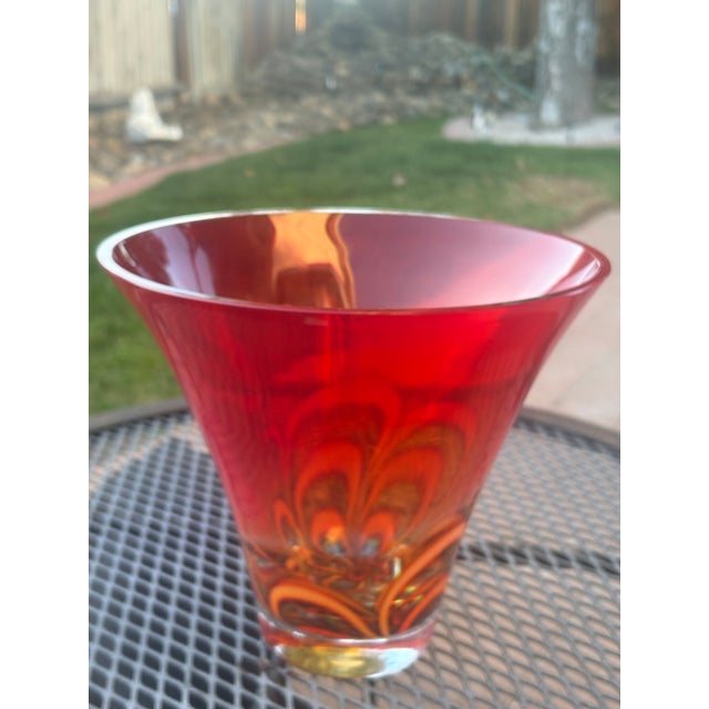This is a hand-blown Evolution by Waterford red and amber art glass bowl featuring a vibrant, fiery swirled pattern....