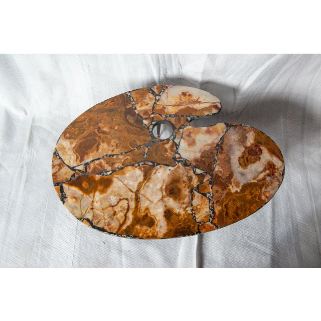 A very unusual small coffee table or side table in marble mosaic in the shape of a painter's palette supported by a trio...