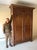 A large 19th century French provincial armoire in warm-toned medium brown oak with a removable stepped cornice crown, tall...