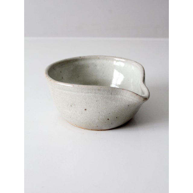 A signed vintage studio pottery batter bowl featuring a spout and handle for both function and style. Its soft, variegated...