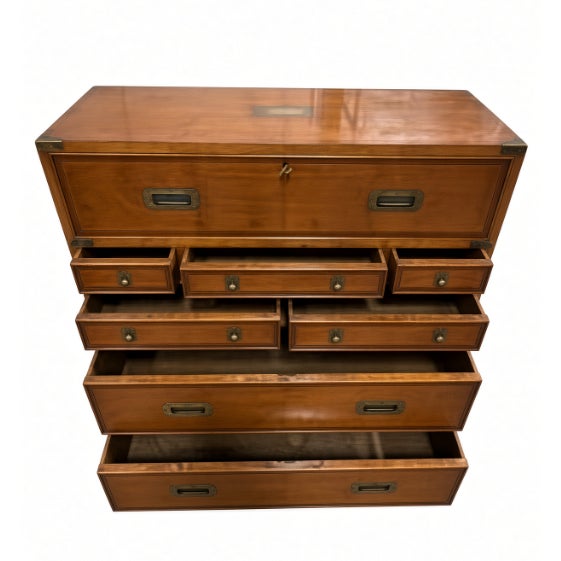 A vintage campaign-style dresser in warm wood with recessed brass pulls and brass corner brackets. Flush drawer fronts,...
