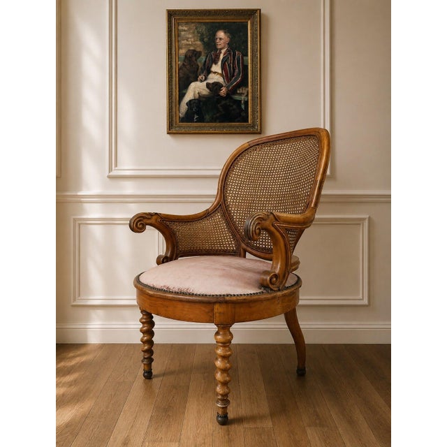 A beautiful antique Victorian cane back armchair with wonderfully sculptural carved wood details, curled arms, a rounded...