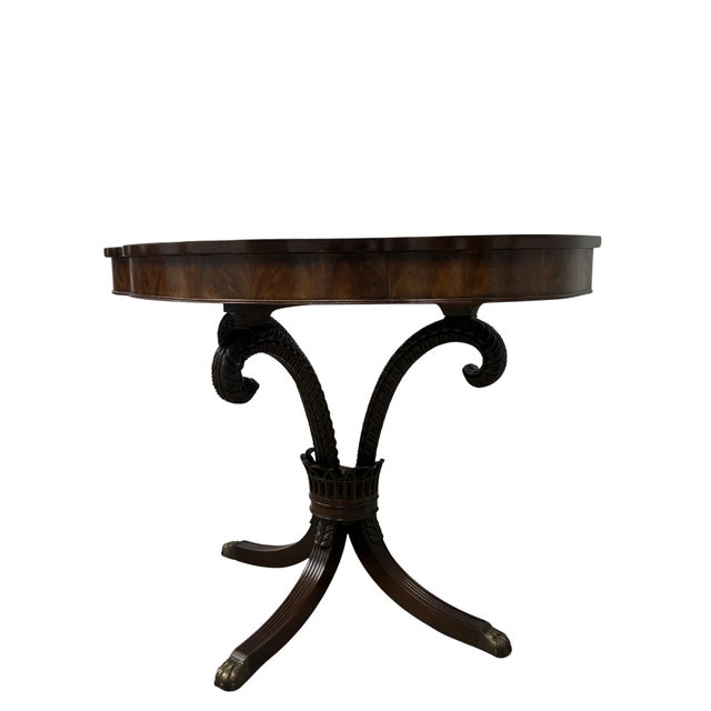 An elegant pair of antique Regency-style demilune console tables crafted in richly figured flame mahogany. Each table...