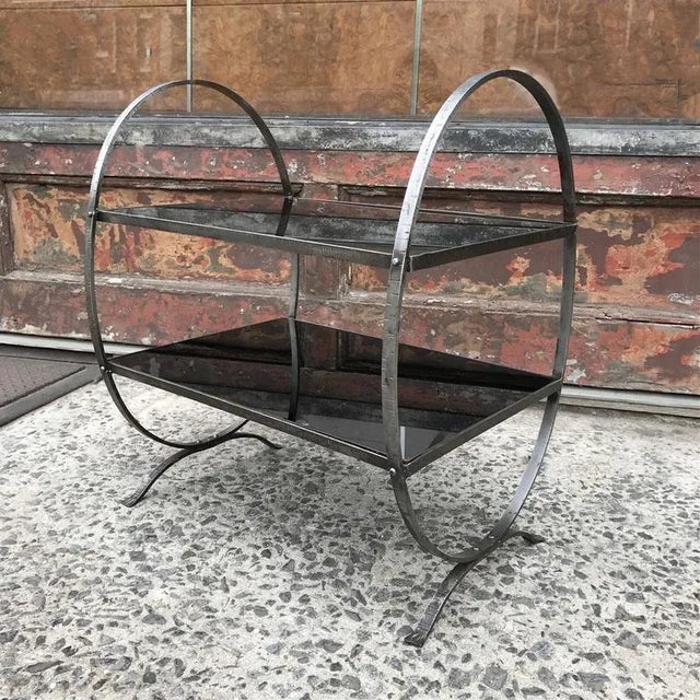 Art Deco, side table featuring looped, etched steel frame with two tiers of black glass; lower shelf is 10" HT and upper...