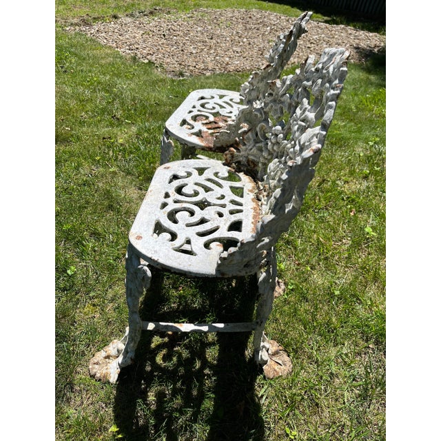 Antique cast iron pair of garden chairs with grape vine motif. Each piece features claw feet and authentic weathered...