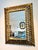 A striking rectangular mirror featuring an intricately detailed gilt frame with antiqued mirrored accents. The frame is...