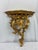 A striking pair of Rococo giltwood wall brackets featuring classic acanthus leaf scrollwork and a warm gold finish. Their...