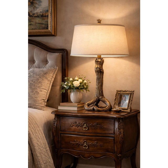 A striking sculptural table lamp featuring an organic, driftwood-inspired form, rendered in a richly layered sunlit bronze...