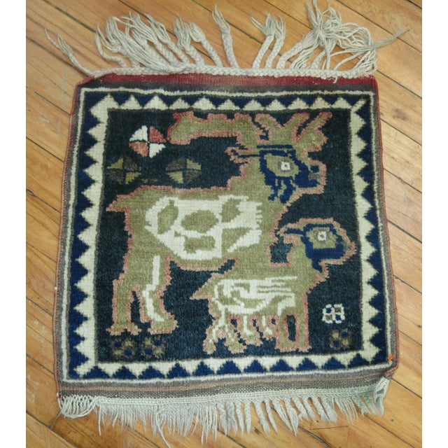 One of a kind hand knotted wool mid 20th Century Persian Pictorial Rug with 2 goats on a charcoal color ground.