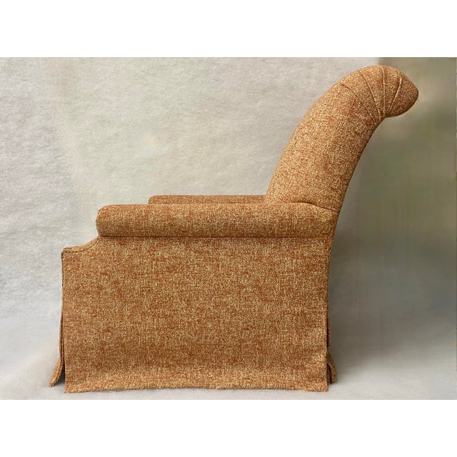 An elegant, classy, and bold rolled-arm chair with a special burnt-orange/amber fabric railed with gold and white threads....