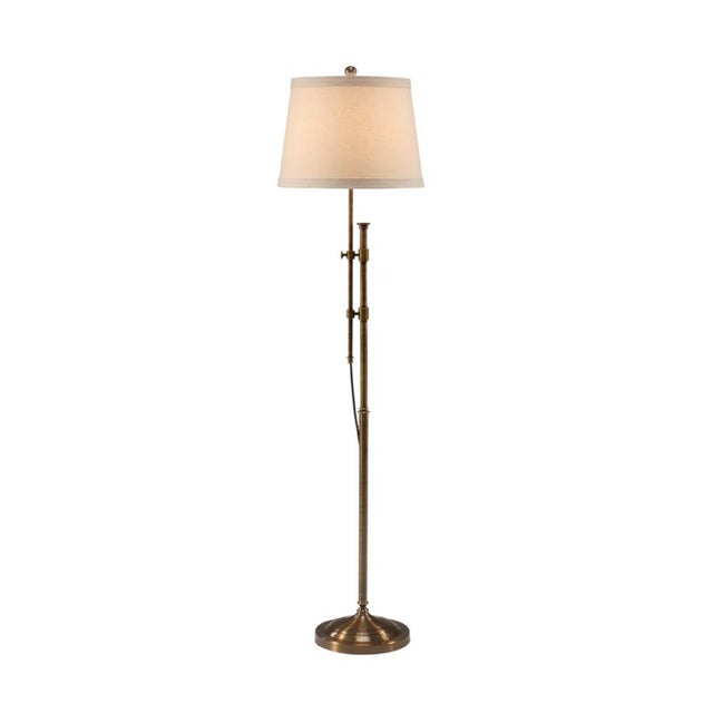 This striking twin column floor lamp is fashioned in brass with an antiqued finish. It features an easily adjustable...