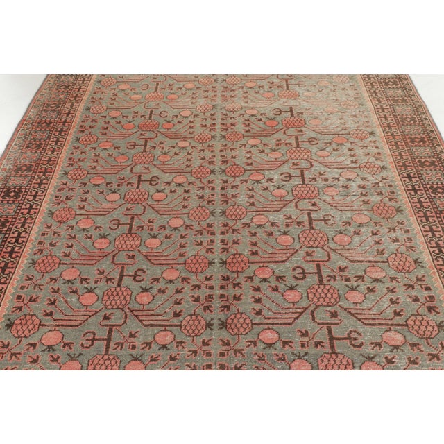 Hand-knotted in wool, this 6x12 antique Khotan runner dates to circa 1920–1930. The design features stylized pomegranate...