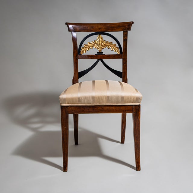 Biedermeier side chair with an upholstered seat and a stained beechwood frame. The unusually designed backrest features...