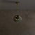 A rare 1970s Italian pendant by Umberto Ghersi—sculpted in ceramic with a cratered surface. The globe shade glows from...
