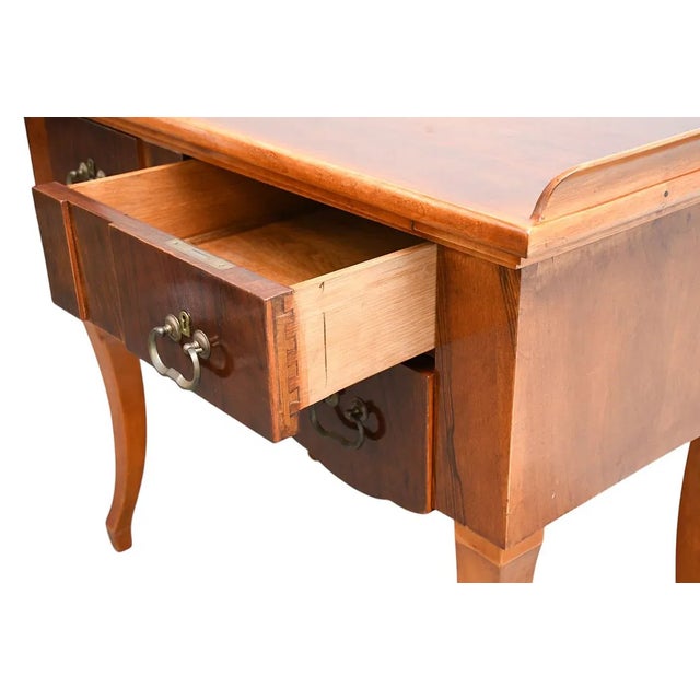 The Biedermeier Mahogany 3 Drawer Side Table with Gallery is a fully assembled antique piece with a rich brown color and...