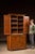 Two-piece walnut stepback cupboard featuring a recessed upper cabinet set back over a deeper lower case, creating the...