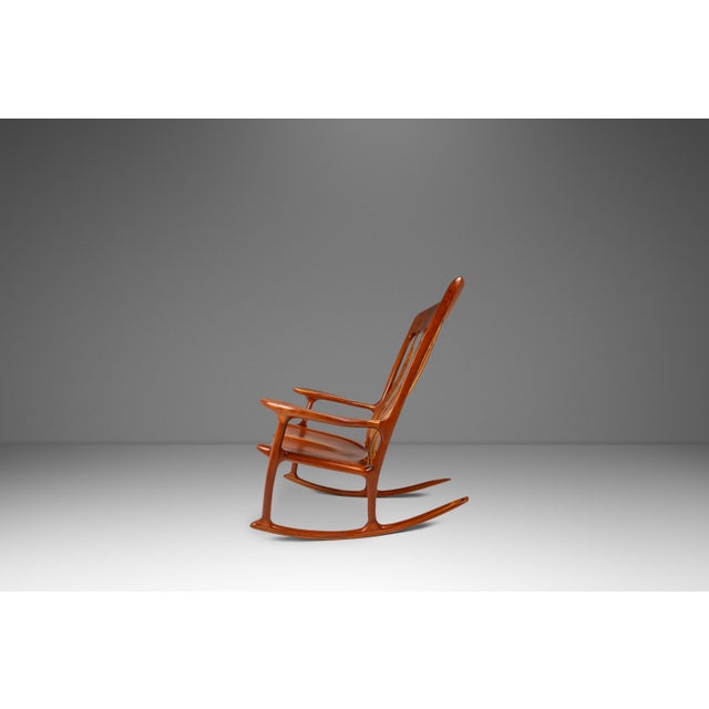 This exceptional studio craft sculptural rocking chair in solid cherry wood is a masterful example of American woodwork...