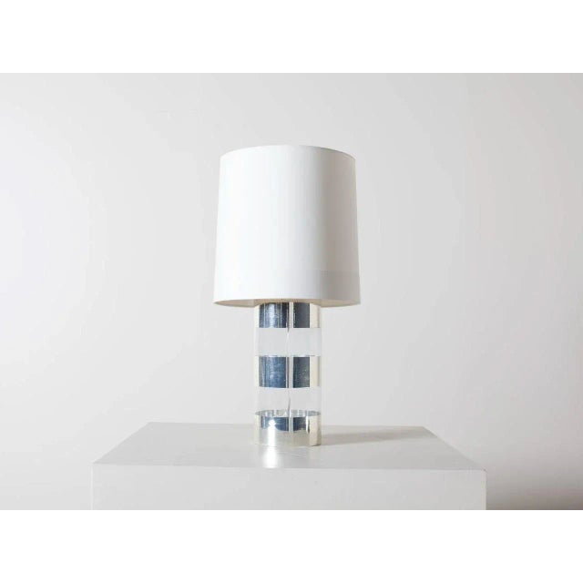 Wide bands of shimmering antiqued mercury silver wrap around large clear glass cylinder. Tall ivory microfiber drum lined...