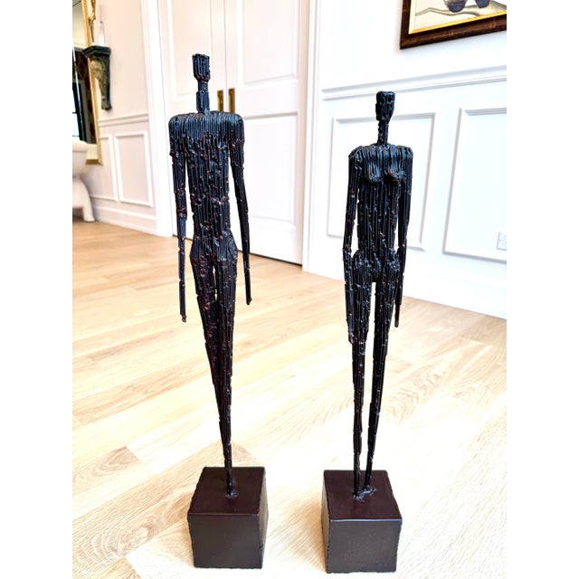 Pair of vintage American Brutalist sculptures depicting elongated male and female figures. Dating to the 1980s, each is...
