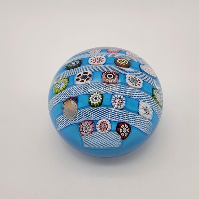 A mesmerizing glass paperweight that captures the intricate artistry of Saint Louis glassmakers in 1972. Delicate white...