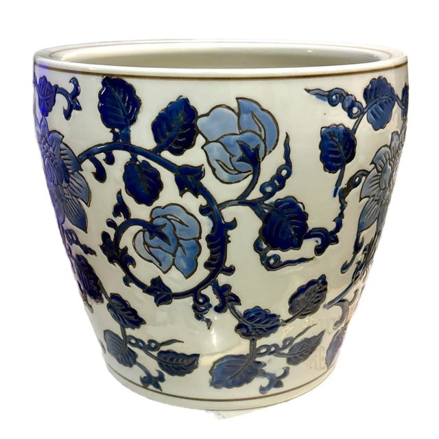 Traditional chinoiserie planter with a blue and white floral vine and leaf design. Great medium sized planter. Drainage...