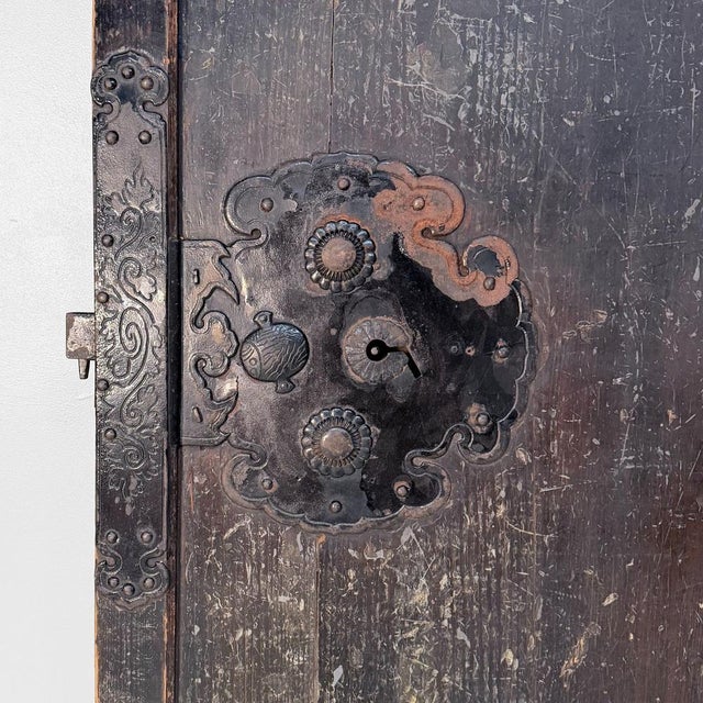 This original Japanese sliding door (hikido) is a powerful architectural object with a deep, dark, timeworn surface and...