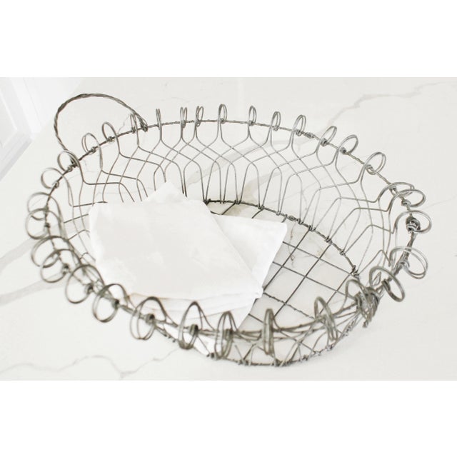 Made in France during the early to mid 1900s, this twisted metal French basket offers charming functionality with a rustic...
