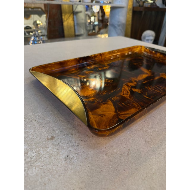 Elegant Italian tray from the 1970s crafted in richly patterned tortoiseshell lucite with sculptural brass end accents....