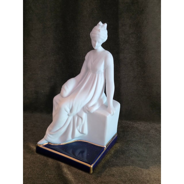 This figurine by the celebrated artist Camille Tharaud of Limoges. This piece features a graceful woman seated in a...