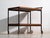 Antique opal serving trolley in wood, with a black tubular steel frame and two trays in amber-lacquered wood on swivel...