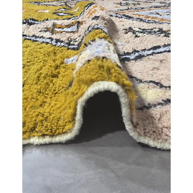Tribal Moroccan Rug – Handmade Berber Wool Rug This vibrant handmade Moroccan rug features a soft beige and ivory base...