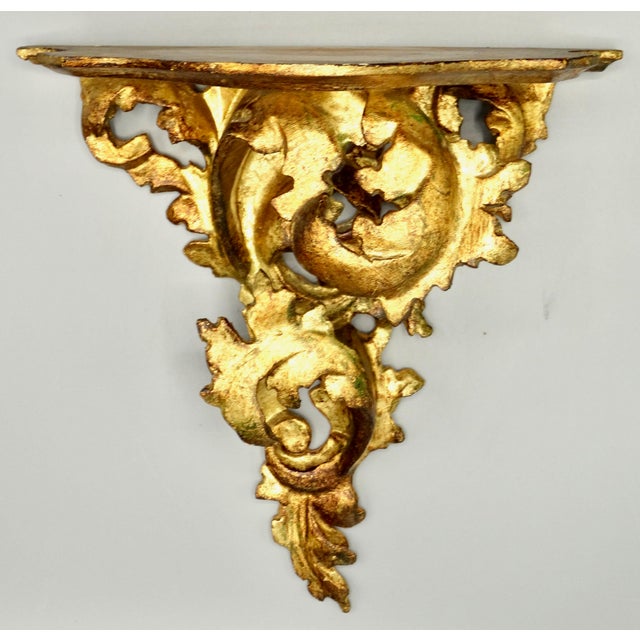 Mid Century Italian carved gilt wood wall bracket with a lovely Neoclassical design. This large scroll form classical wall...