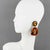 Those fabulous Lucite dangling clip-on earrings boast a chandelier shape with a geometric carved design in luminous amber...
