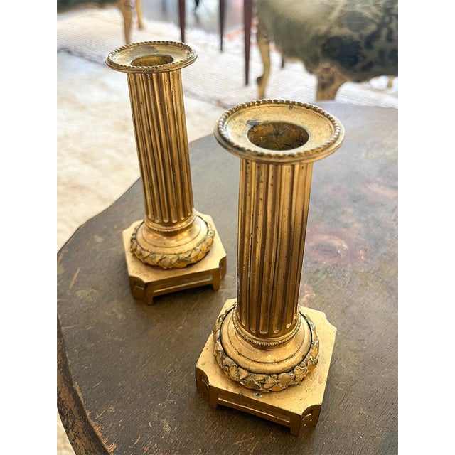 These gilt bronze candlesticks are small in scale, but substantial in feel and presence. They can add charm to any table...
