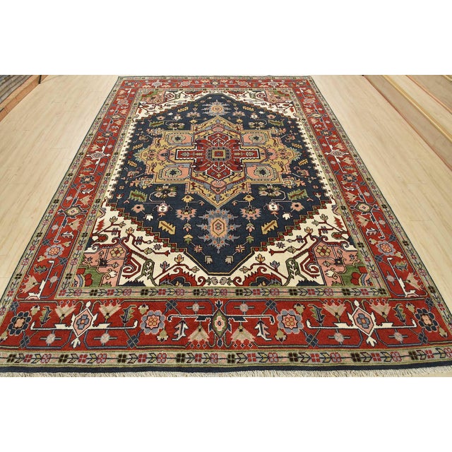 A traditional tribal Heriz rug hand-knotted with an all-wool pile on a cotton foundation. This oriental rug features a...