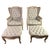Pair of French carved bleached walnut wingback armchairs w/ matching ottomans. The chairs and ottomans stand on cabriole...