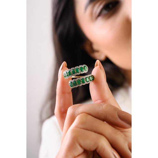 This statement wrap ring showcases 14 vivid oval-cut Zambian emeralds totaling 1.92 carats, set in rich 14k yellow gold....