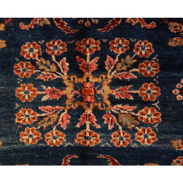 A beautiful early 20th century Persian Lilihan rug with an all-over field of flowers on a rich indigo background,...