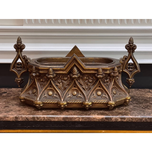 A substantial cast bronze planter in the Gothic Revival taste, the body cast with pointed arch arcading filled with...