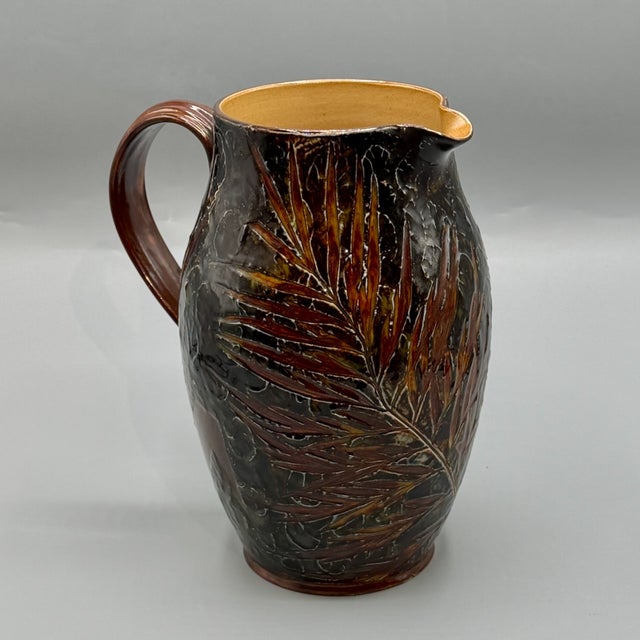A substantial antique Royal Doulton Lambeth stoneware pitcher decorated in the celebrated Natural Foliage Ware technique,...