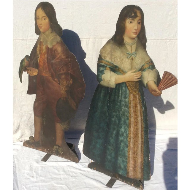 Beautiful antique English painted oak dummy boards. Their clothing is early 18th Century and the male is holding a bird...