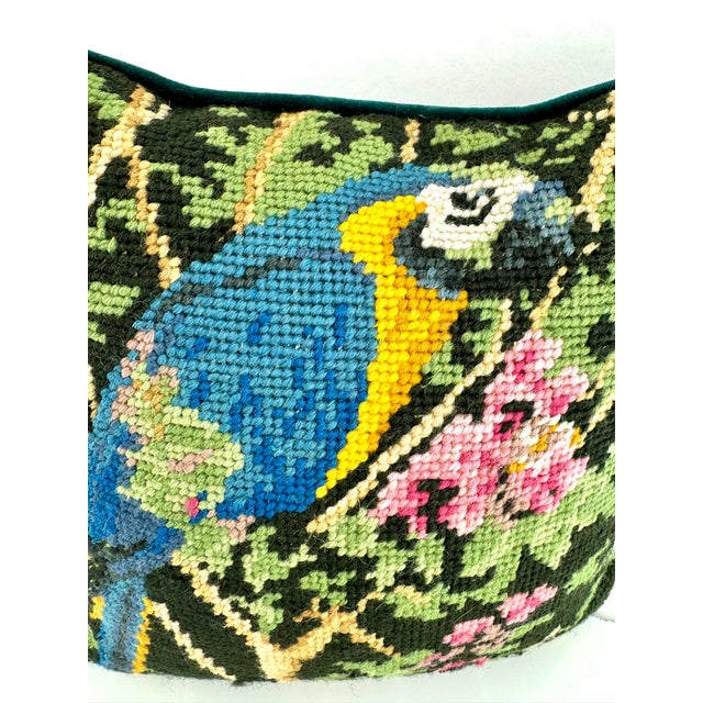 This vintage pillow features a vibrant needlepoint design of a parrot amidst a floral backdrop. The rich colors of the...