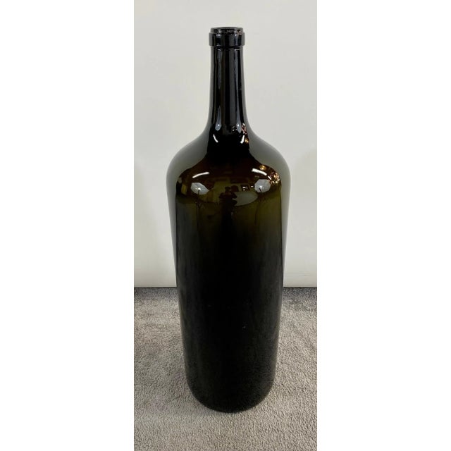 A large pair of vintage dark green blown glass Demijohn style bottles of wines. The bottles are sturdy and very...