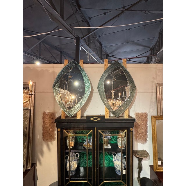 The product is a pair of modernist Murano mirrors in a Fontana Green color. These mirrors are very striking and sure to...