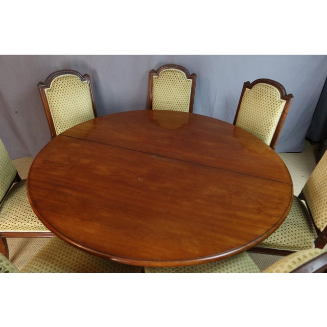 Large solid wood dining table from maison jeanselme in paris. This napoleon iii period table is almost round with numerous...