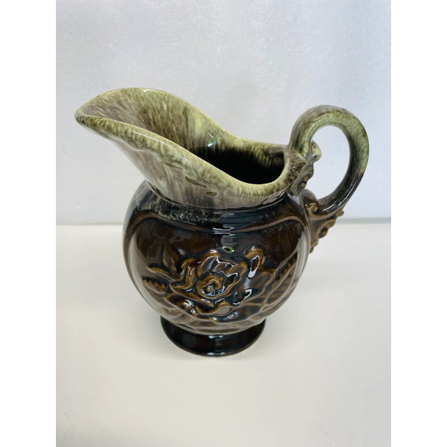 Vintage brown and green with rose pattern pottery pitcher 7" X 7" , makers mark reads " HULL" Very good condition.