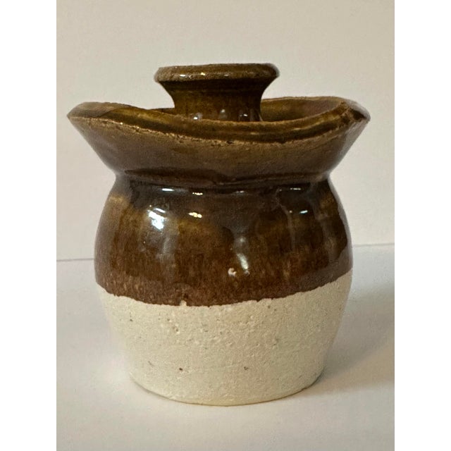 This is a handmade brown and cream colored honey jar pottery piece. It could be used as a candlestick holder or as a vase....